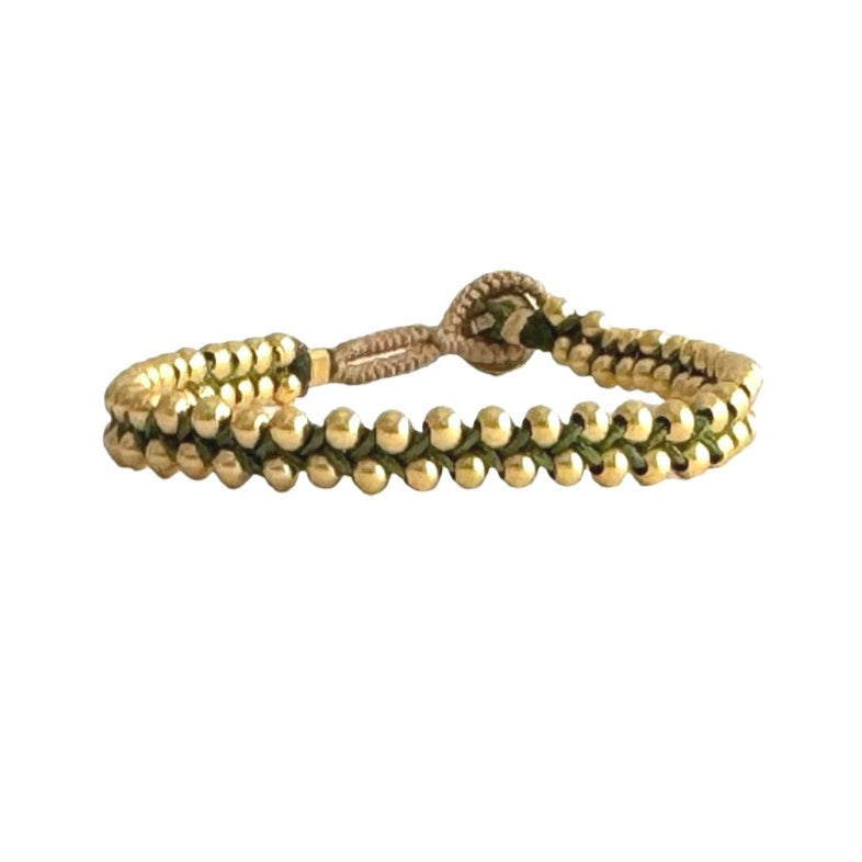 Detailed view of statement bracelet in gold, handcrafted with beaded design.