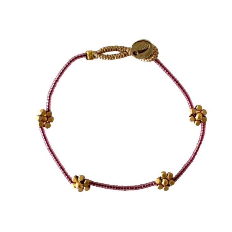 Feminine beaded bracelet with gold-toned floral details.